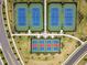 Aerial view of multiple tennis courts surrounded by grass and trees in the planned community at 5117 Marina Basin Ct, Bradenton, FL 34211