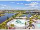 Aerial view of community waterpark featuring splash pad, lounge chairs, lakes, and multiple recreational courts at 5117 Marina Basin Ct, Bradenton, FL 34211