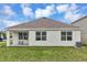 Exterior of the home features a grassy backyard, a covered patio and white walls at 5121 Sultana Cv, Bradenton, FL 34211