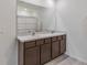 Bathroom with double sink vanity featuring dark wood cabinets, light countertops and a large mirror at 5121 Sultana Cv, Bradenton, FL 34211