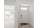Bright foyer featuring tile flooring, a front door with transom window, and an open view to a living area at 5121 Sultana Cv, Bradenton, FL 34211