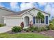 Inviting single-story home with a two-car garage, decorative shutters, complemented by lush landscaping and a palm tree at 5121 Sultana Cv, Bradenton, FL 34211