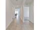 Neutral hallway with tile floors providing access to various rooms including a dining area and carpeted room at 5121 Sultana Cv, Bradenton, FL 34211