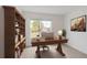 Home office with a large desk, bookcase, and view of a palm tree at 5121 Sultana Cv, Bradenton, FL 34211