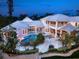 Stunning aerial view of home featuring a pool, hot tub, fire pit and luxurious outdoor living space at dusk at 5132 Jungle Plum Rd, Sarasota, FL 34242