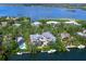 Aerial view of estate home featuring a pool, lush landscaping, a private dock, and water access at 5132 Jungle Plum Rd, Sarasota, FL 34242