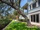 Serene backyard view with lush landscaping, a unique tree swing, and a glimpse of the home's exterior at 5132 Jungle Plum Rd, Sarasota, FL 34242