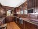Elegant home bar with rich wood cabinetry, marble countertops, and ample storage at 5132 Jungle Plum Rd, Sarasota, FL 34242