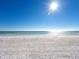 Panoramic view of a sun-drenched beach with gentle waves meeting the shore under a clear blue sky at 5132 Jungle Plum Rd, Sarasota, FL 34242