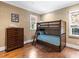 Cozy bedroom featuring a wooden bunk bed, hardwood floors, and charming decor at 5132 Jungle Plum Rd, Sarasota, FL 34242