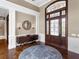 Grand foyer featuring a decorative glass door, hardwood floors, elegant console table, and refined lighting fixtures at 5132 Jungle Plum Rd, Sarasota, FL 34242