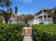 Elegant home exterior showcasing a beautifully landscaped yard, private walkway and a large, covered balcony at 5132 Jungle Plum Rd, Sarasota, FL 34242