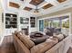 Spacious living room with coffered ceilings, a fireplace, built-in shelving, and sliding glass doors to the outside at 5132 Jungle Plum Rd, Sarasota, FL 34242