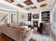 Comfortable living room with fireplace, built-in shelving, coffered ceilings, and view of the stairs at 5132 Jungle Plum Rd, Sarasota, FL 34242