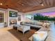 Cozy covered outdoor living room with a fireplace, TV and comfortable seating for relaxing or entertaining at 5132 Jungle Plum Rd, Sarasota, FL 34242