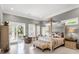 Main bedroom with sitting area, balcony access, and a stylish four-poster bed at 5132 Jungle Plum Rd, Sarasota, FL 34242