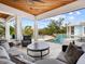 Luxurious covered patio with comfortable seating and a stunning view of the pool and landscaped backyard at 5132 Jungle Plum Rd, Sarasota, FL 34242