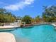 Beautiful swimming pool with a charming waterfall feature and lush landscaping, creating a serene oasis at 5132 Jungle Plum Rd, Sarasota, FL 34242