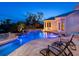 Backyard swimming pool and spa with beautiful lighting, waterfall feature, and surrounding landscaping at 5132 Jungle Plum Rd, Sarasota, FL 34242