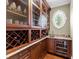 Sophisticated wet bar with custom cabinetry, granite countertops, wine storage, and a charming circular window at 5132 Jungle Plum Rd, Sarasota, FL 34242