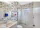 Nautical bathroom with patterned wallpaper, a glass shower and a white vanity at 5320 Tide Point Way, Bradenton, FL 34208