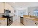 Well-lit kitchen with stainless steel appliances, white cabinetry, tile floors and countertop space for food preparation at 5320 Tide Point Way, Bradenton, FL 34208