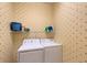 Cozy laundry room featuring a stacked washer and dryer with overhead shelving and star pattern wall paper at 5320 Tide Point Way, Bradenton, FL 34208