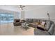 Spacious living room featuring tile flooring, comfortable seating, and a view of the screened lanai and private pool at 5320 Tide Point Way, Bradenton, FL 34208
