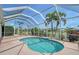 A screened-in pool with waterfall feature is surrounded by landscaping and views of the lake at 5320 Tide Point Way, Bradenton, FL 34208