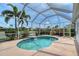 A luxurious screened-in pool with a waterfall feature overlooks a serene lake and meticulously maintained landscaping at 5320 Tide Point Way, Bradenton, FL 34208
