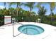Community spa with clear blue water surrounded by tropical landscaping, with posted spa rules at 5320 Tide Point Way, Bradenton, FL 34208