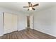 Bedroom showcasing wood floors, closet, ceiling fan, and view into en-suite bathroom at 5710 16Th W St, Bradenton, FL 34207