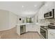 Modern kitchen featuring white cabinets, stainless steel appliances, and a quartz countertop island with bar seating at 5985 Amberly Dr, Bradenton, FL 34208