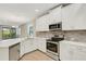 Modern kitchen featuring stainless appliances, white cabinetry and a quartz countertop island with bar seating at 5985 Amberly Dr, Bradenton, FL 34208