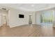 Bright living room with hardwood flooring, a ceiling fan, and a large window for ample natural light at 5985 Amberly Dr, Bradenton, FL 34208