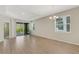 Open-concept living room with hardwood floors, large windows, and sliding glass doors to outdoor area at 5985 Amberly Dr, Bradenton, FL 34208