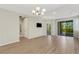 Bright living room featuring hardwood floors, modern lighting, and sliding doors to the outdoor space at 5985 Amberly Dr, Bradenton, FL 34208