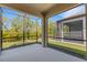 A covered, screened-in lanai offers views of the backyard and landscaping at 5985 Amberly Dr, Bradenton, FL 34208