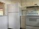 A traditional kitchen featuring white appliances and ample storage space at 6074 Arlene Way # 5, Bradenton, FL 34207