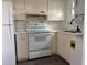 Functional kitchen featuring white cabinets, appliances, and a built-in laundry area at 6074 Arlene Way # 5, Bradenton, FL 34207