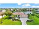 Aerial view of home with a tile roof, three-car garage, circular driveway, and mature tropical landscaping at 6143 9Th Avenue Ne Cir, Bradenton, FL 34212
