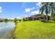 Sprawling backyard leading to a lake with a covered patio attached to the rear of the house at 6143 9Th Avenue Ne Cir, Bradenton, FL 34212