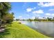 Backyard lake view with lush greenery and palm trees creating a serene scene at 6143 9Th Avenue Ne Cir, Bradenton, FL 34212