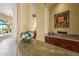 Close-up of a stylish bar area with a granite countertop and wood cabinets at 6143 9Th Avenue Ne Cir, Bradenton, FL 34212