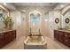 Luxurious bathroom with a soaking tub, dual vanities, and a walk-in shower, designed for relaxation at 6143 9Th Avenue Ne Cir, Bradenton, FL 34212