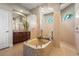 A luxurious bathroom features a tiled spa tub, walk in shower and dual sinks at 6143 9Th Avenue Ne Cir, Bradenton, FL 34212