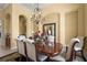 Dining room with elegant wood table, upholstered chairs, overhead chandelier, and arched design elements at 6143 9Th Avenue Ne Cir, Bradenton, FL 34212