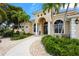 The home's front entrance with a covered porch, double doors, white pillars, and meticulously maintained landscaping at 6143 9Th Avenue Ne Cir, Bradenton, FL 34212
