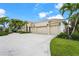 Well-manicured lawn along an expansive driveway leading to the tan colored home with attached three-car garage at 6143 9Th Avenue Ne Cir, Bradenton, FL 34212