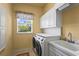 Functional laundry room includes washer, dryer, storage cabinets and sink near the window at 6143 9Th Avenue Ne Cir, Bradenton, FL 34212
